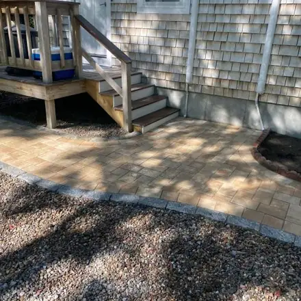 Brick paver patio beside a deck