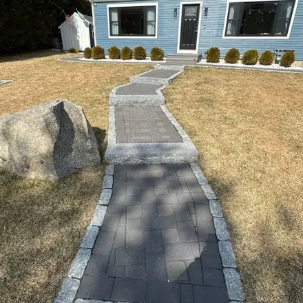 Stone walkway leading to a blue house